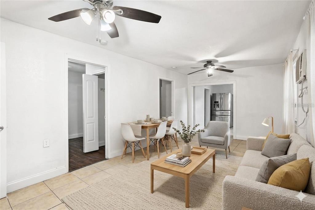 A living room and dining area with tile floors, white walls, and two ceiling fans — 313 E BOOKER STREET, AVON PARK, FL
