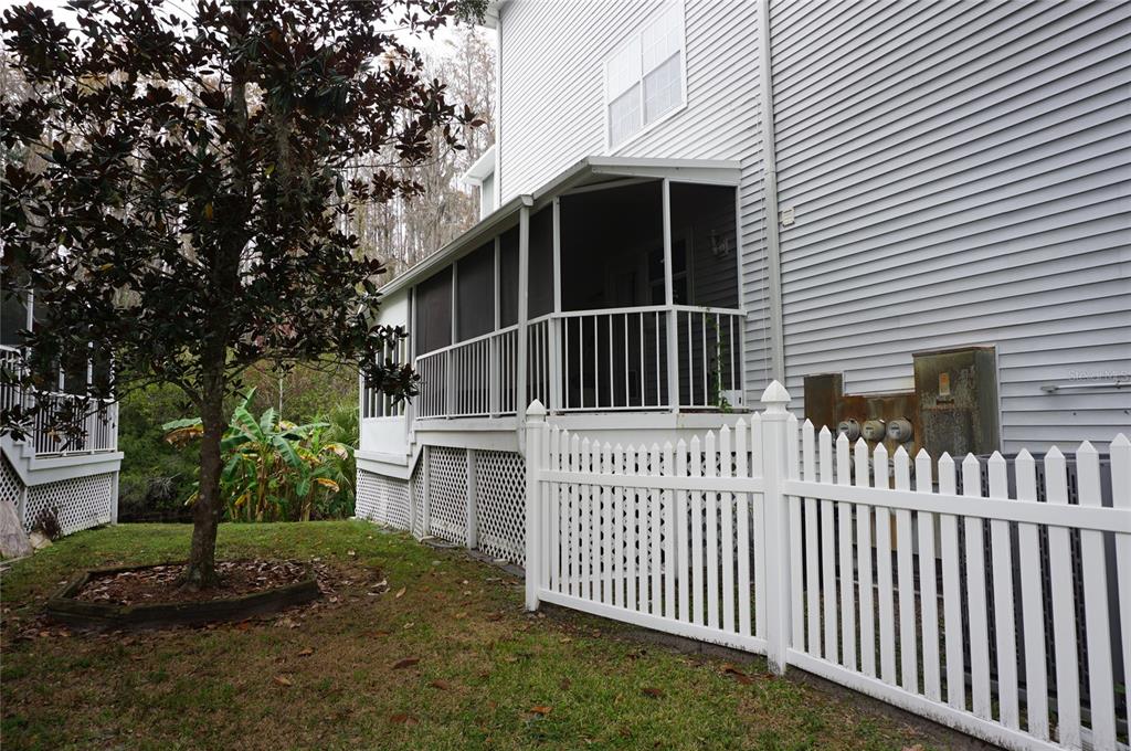 A white vinyl fence stands in front of a house with a screened-in porch — 2051 VISTA DEL SOL CIRCLE UNIT 201, LUTZ, FL