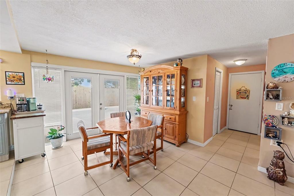 A dining area features a wooden table, hutch, tile flooring, and glass doors to the outside — 9537 CRESTVIEW STREET, SEMINOLE, FL