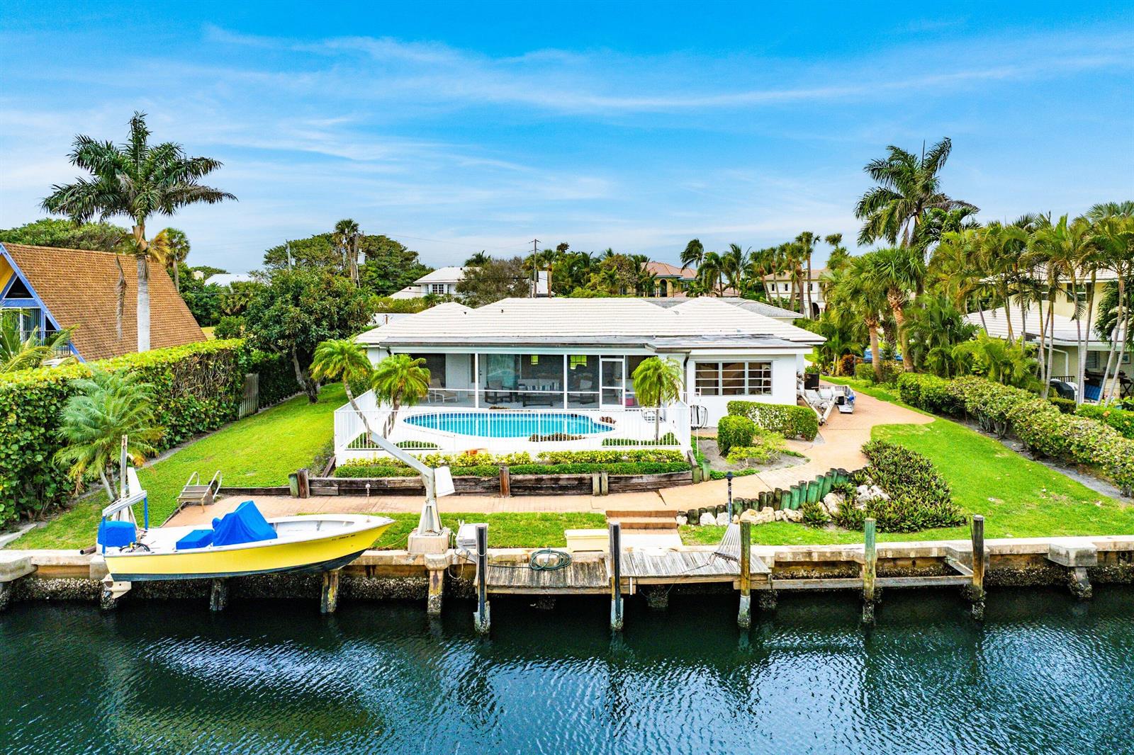 An aerial view of a waterfront house with a swimming pool, boat dock, and boat — 23 Sabal Island Drive, Ocean Ridge FL 33435, OCEAN RIDGE, FL