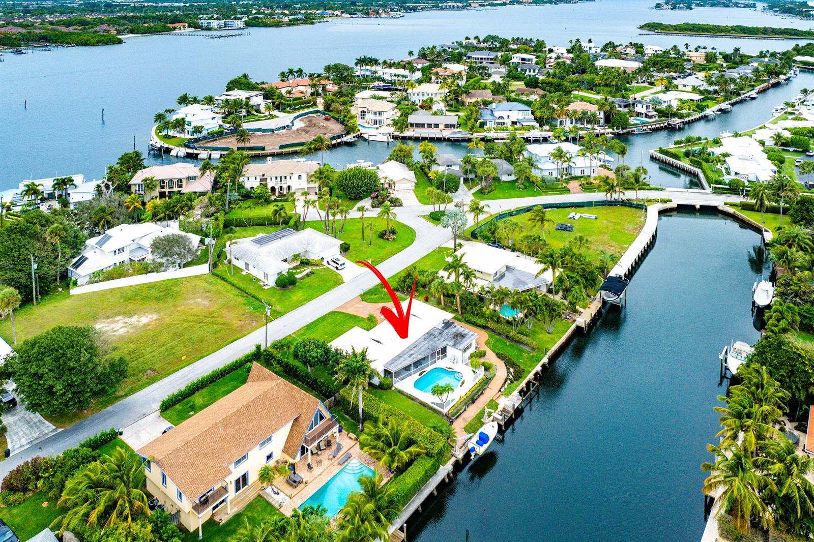 An aerial view shows a waterfront house with a pool and a boat dock — 23 Sabal Island Drive, Ocean Ridge FL 33435, OCEAN RIDGE, FL