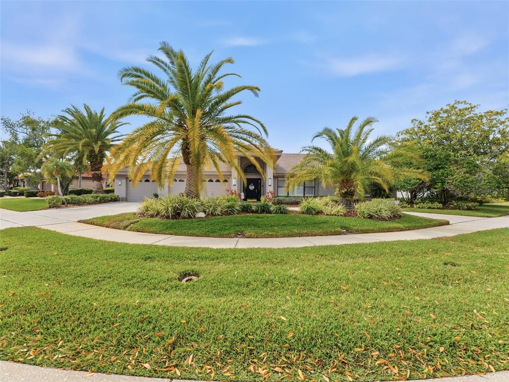 A single-story house with a three-car garage and palm trees in the front yard — 4830 LONGWATER WAY, TAMPA, FL