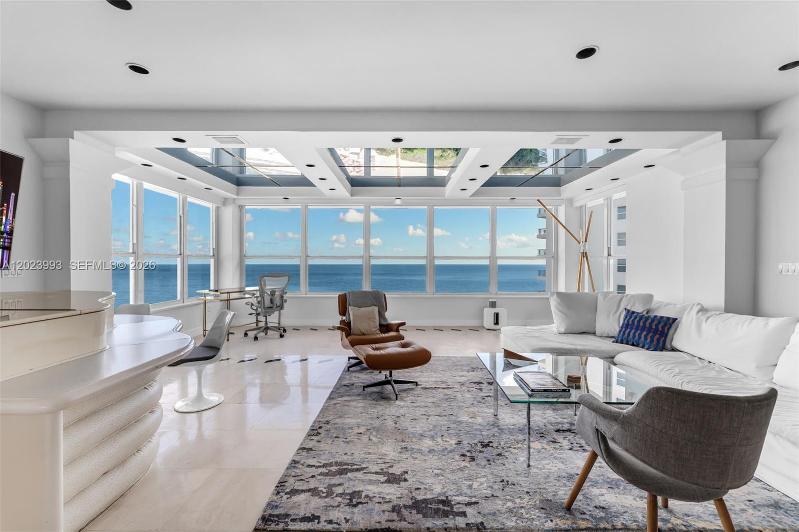 A bright living room features floor-to-ceiling windows with ocean views and a coffered ceiling — 4925 Collins Ave # 11E, Miami Beach FL 33140, MIAMI BEACH, FL
