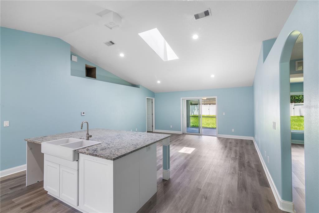 A kitchen island with a farmhouse sink sits in a room with light blue walls — 21 LAKE CHARLES LANE, PALM COAST, FL