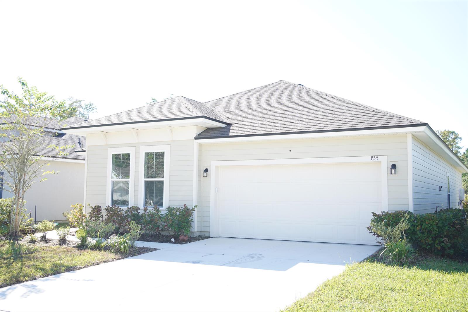 A single-story house with light siding, a two-car garage, and a shingled roof — 855 Sycamore Way, FL 32073, FL