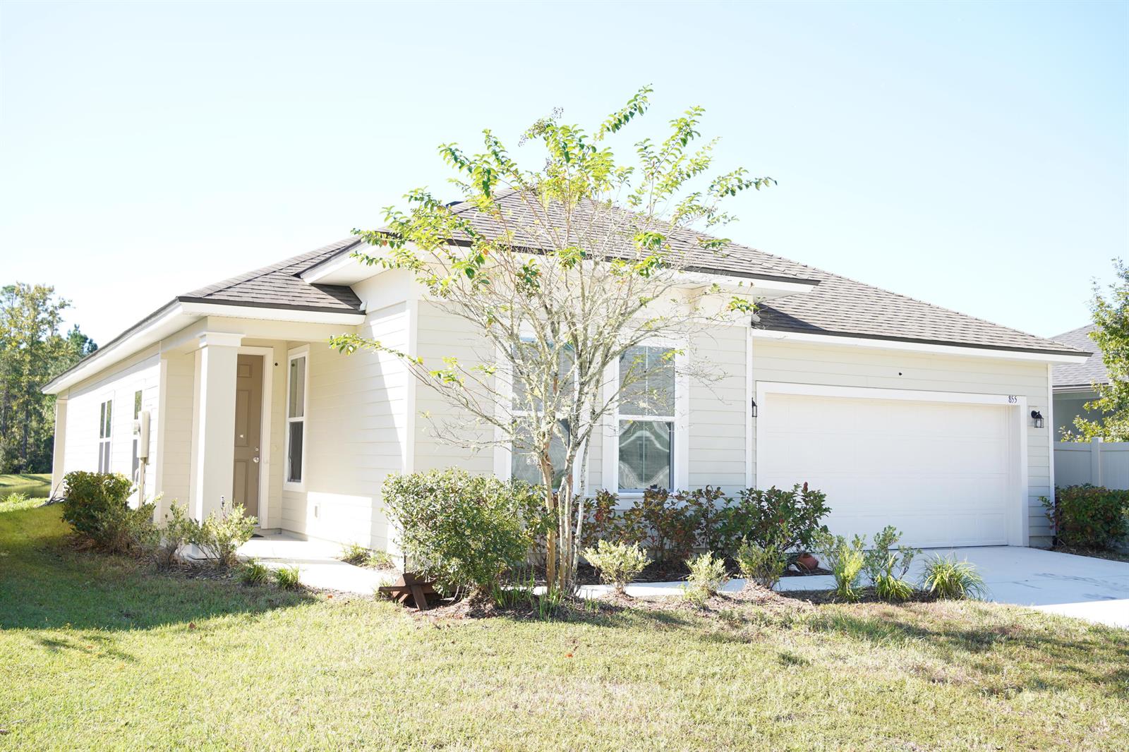 A single-story house with light-colored siding, a two-car garage, and a small front yard — 855 Sycamore Way, FL 32073, FL