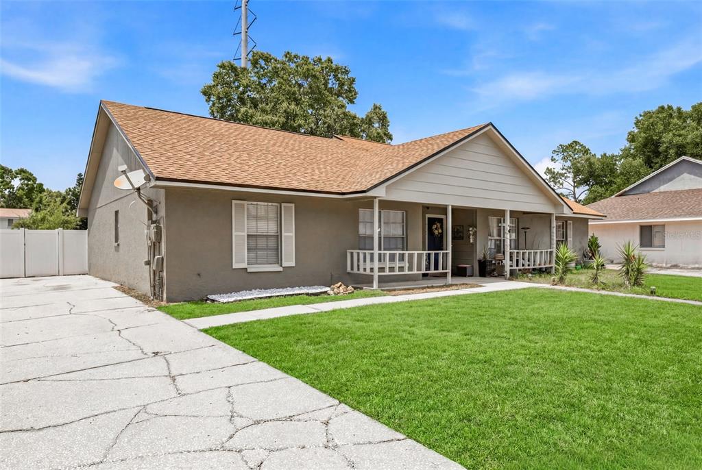 A single-story house with a tan exterior, brown shingled roof, and a front porch — 3257 LAUREL DALE DRIVE, TAMPA, FL