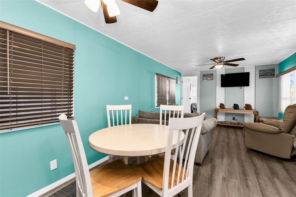 A dining area with a round table and chairs opens into a living room — 6442 HIKINA DRIVE, NORTH PORT, FL