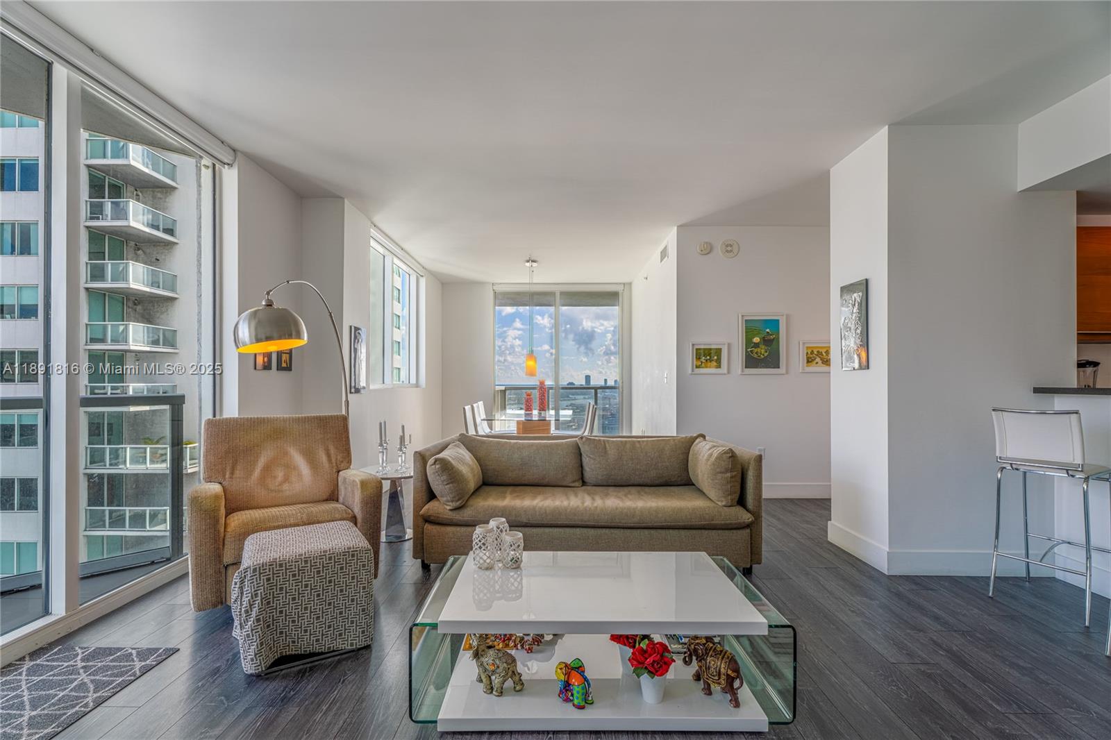 A modern living room features dark wood floors, a beige sofa, and a glass coffee table — 253 NE 2nd St # 3203, Miami FL 33132, MIAMI, FL