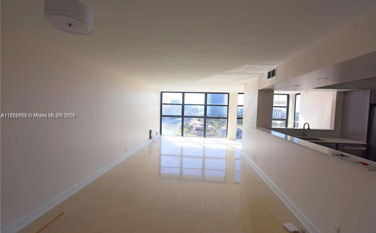 An empty living area with light tile flooring features a large window overlooking the water — 200 Leslie Dr # 1124, Hallandale Beach FL 33009, HALLANDALE BEACH, FL