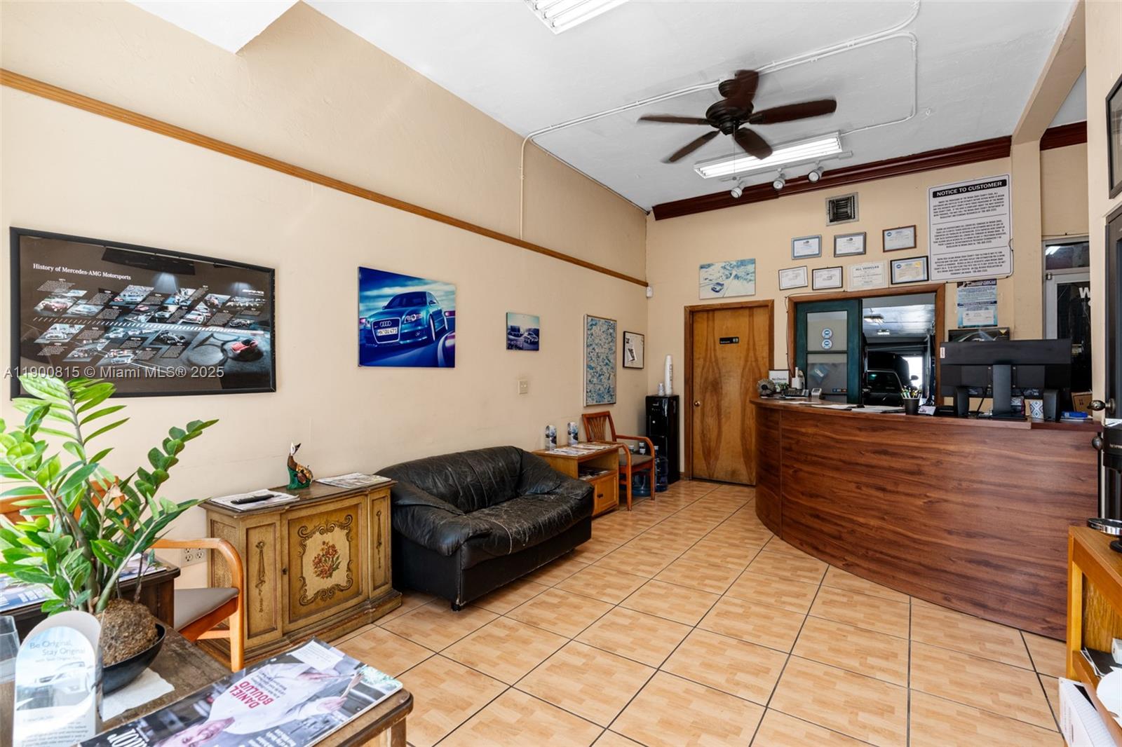 A waiting area with a reception desk, black leather sofa, and tiled flooring — 3771 Bird Rd, Miami FL 33146, MIAMI, FL