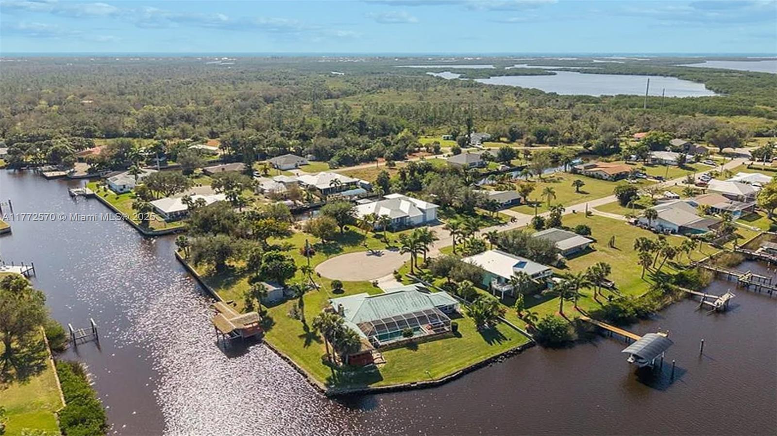 An aerial view shows a waterfront house with a pool and dock on a canal — 28450 Sabal Palm Dr, Punta Gorda FL 33982, PUNTA GORDA, FL