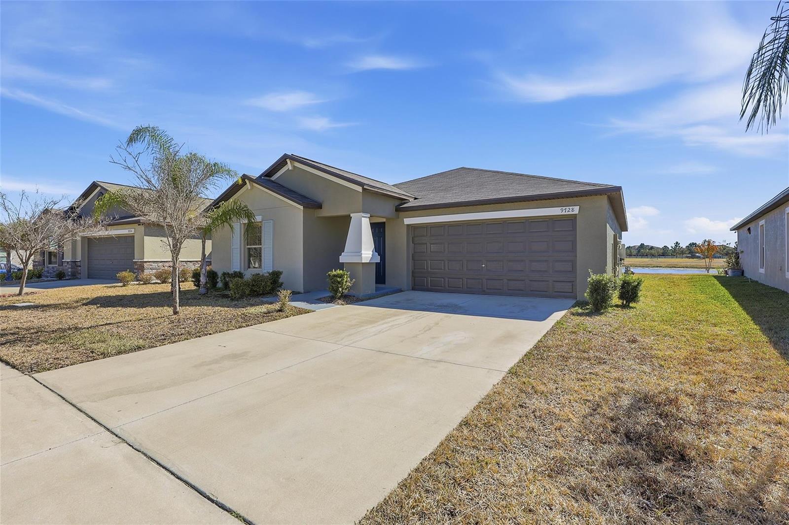 A single-story house with a concrete driveway, a two-car garage, and a tan exterior — 9728 Channing Hill Drive, FL 33573, FL