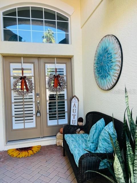 A front entryway features double doors with wreaths, a wicker bench, and a wall decoration — 7236 ORCHID ISLAND PLACE, BRADENTON, FL