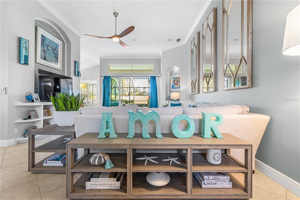 A living room features a sofa, a console table with "amor" decor, and large wall mirrors — 7236 ORCHID ISLAND PLACE, BRADENTON, FL
