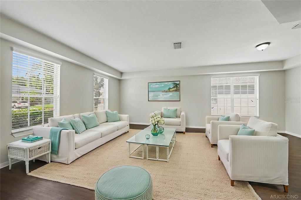 A living room features white sofas, a glass coffee table, and a light-colored area rug — 6112 CEZANNE AVENUE, LUTZ, FL