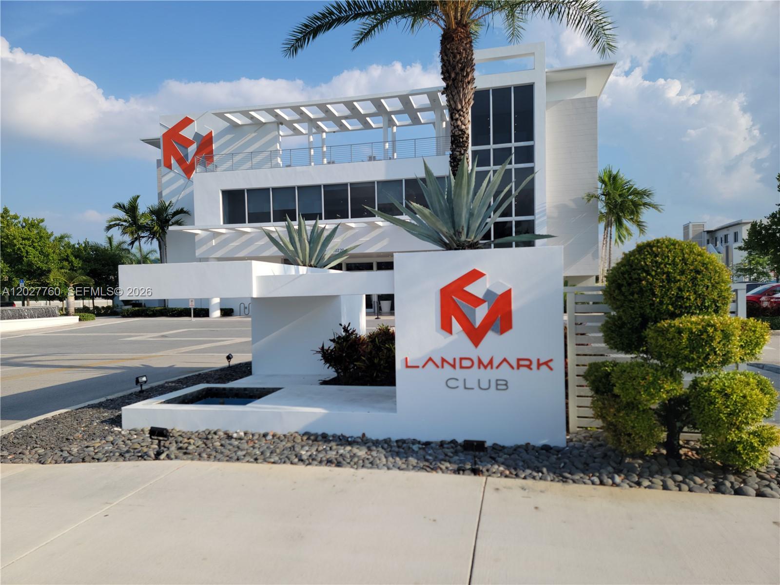 A modern white building with a Landmark Club sign and a palm tree in front — 6310 NW 103rd Pl # 202, Doral FL 33178, DORAL, FL