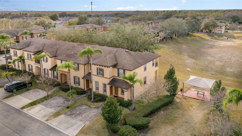 An aerial view of a multi-story tan apartment building with a paved parking area — 2153 CALABRIA AVENUE, DAVENPORT, FL