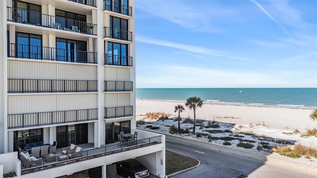 An exterior view of a multi-story beachside condominium building with balconies overlooking the ocean — 1400 GULF BOULEVARD UNIT 109, CLEARWATER BEACH, FL