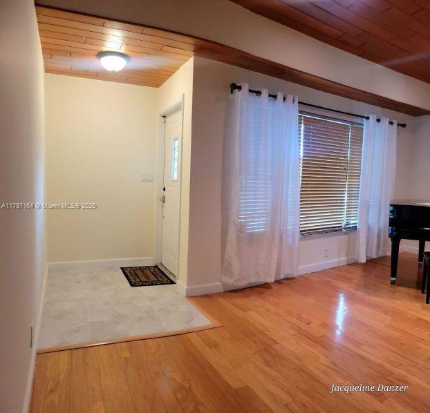 An entryway with tile flooring leads into a living area featuring hardwood floors and wood-paneled ceilings — 2241 NE 38th St # 0, Lighthouse Point FL 33064, LIGHTHOUSE POINT, FL