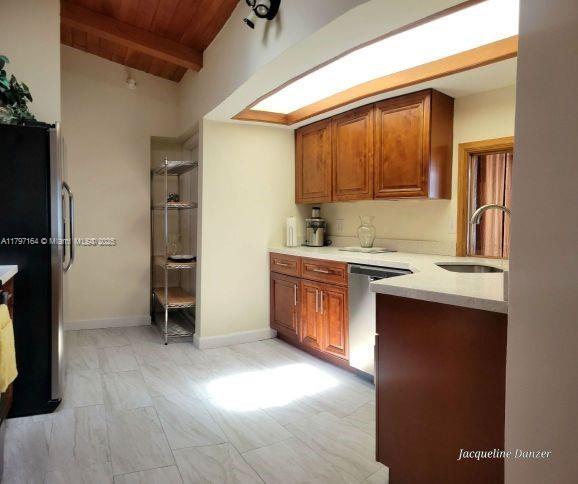 A kitchen features wood cabinets, stainless steel appliances, and light-colored tile flooring — 2241 NE 38th St # 0, Lighthouse Point FL 33064, LIGHTHOUSE POINT, FL