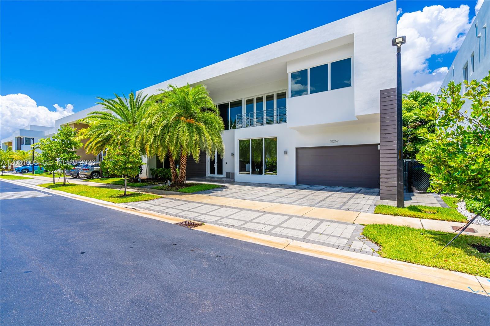 A modern two-story white house features a paved driveway, a garage, and palm trees — 10267 NW 75th Ter # 10267, Doral FL 33178, DORAL, FL