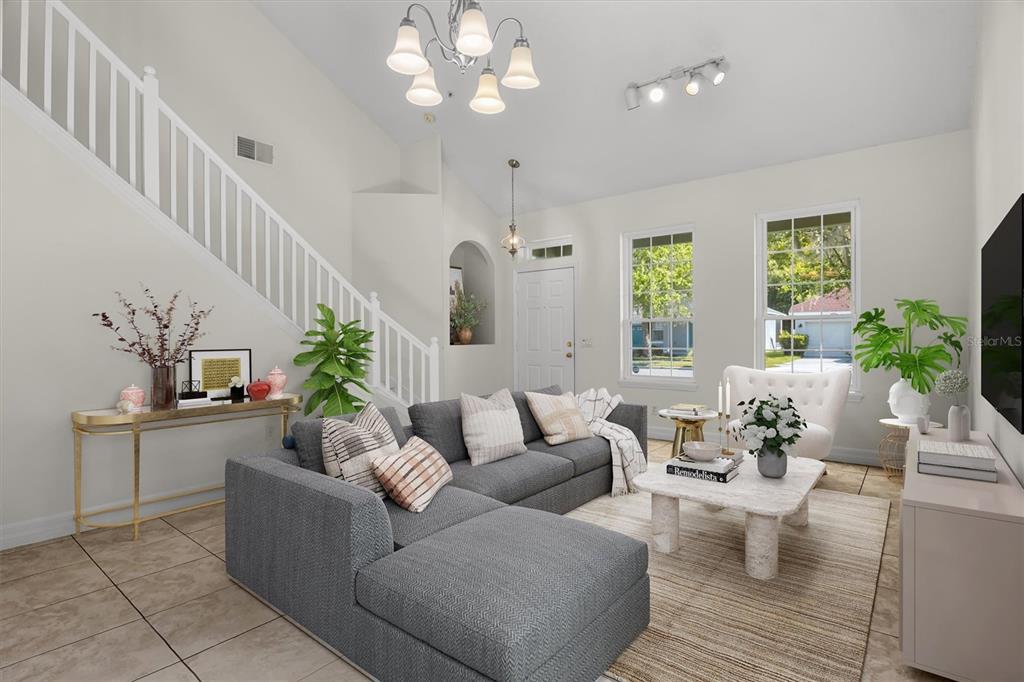 A living room features a gray sectional sofa, a marble coffee table, and a staircase — 10550 EASTPARK WOODS DRIVE, ORLANDO, FL