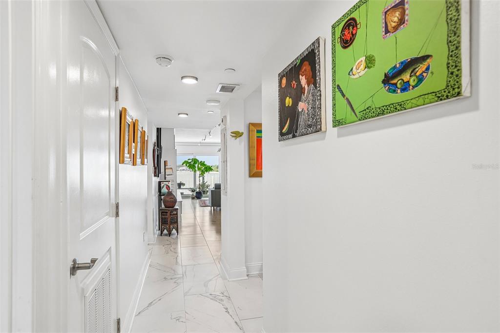 An exterior view of a building entrance with white textured block walls and a door — 2 ADALIA AVENUE UNIT 301, TAMPA, FL