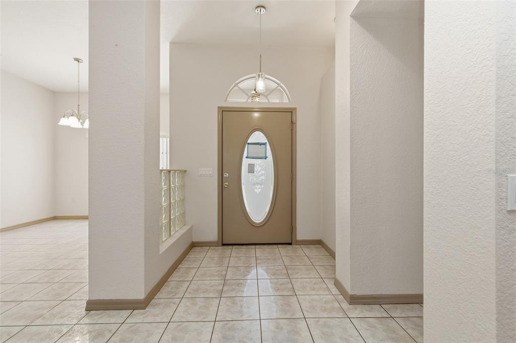 A tiled entryway features a beige front door with an oval glass insert and transom — 191 ROSEMARY STREET, PORT CHARLOTTE, FL