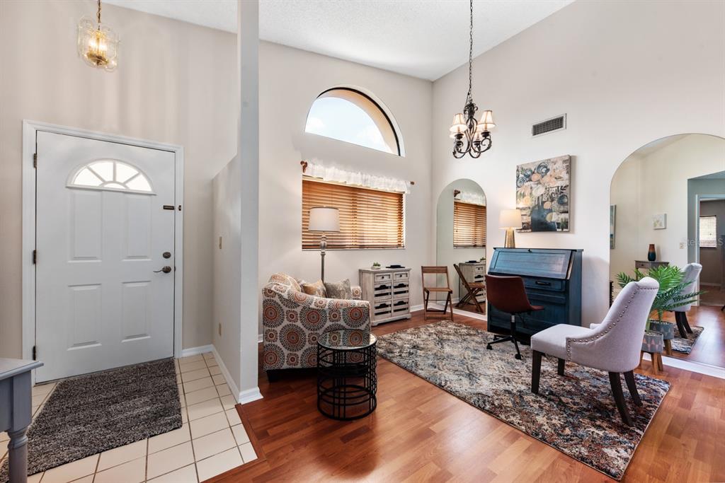 A bright entryway leads into a living area with high ceilings, wood floors, and furniture — 5656 ASHTON LAKE DRIVE UNIT 5656, SARASOTA, FL