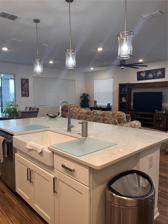 A kitchen island with a farmhouse sink and pendant lighting overlooks a living room area — 9222 SW 104TH TERRACE, OCALA, FL