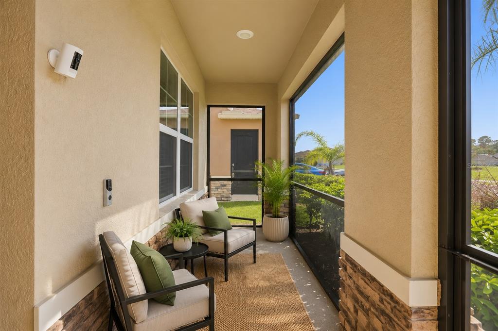 A screened-in patio features two chairs, a small table, and a view of the yard — 531 LAZIO CIRCLE, DEBARY, FL