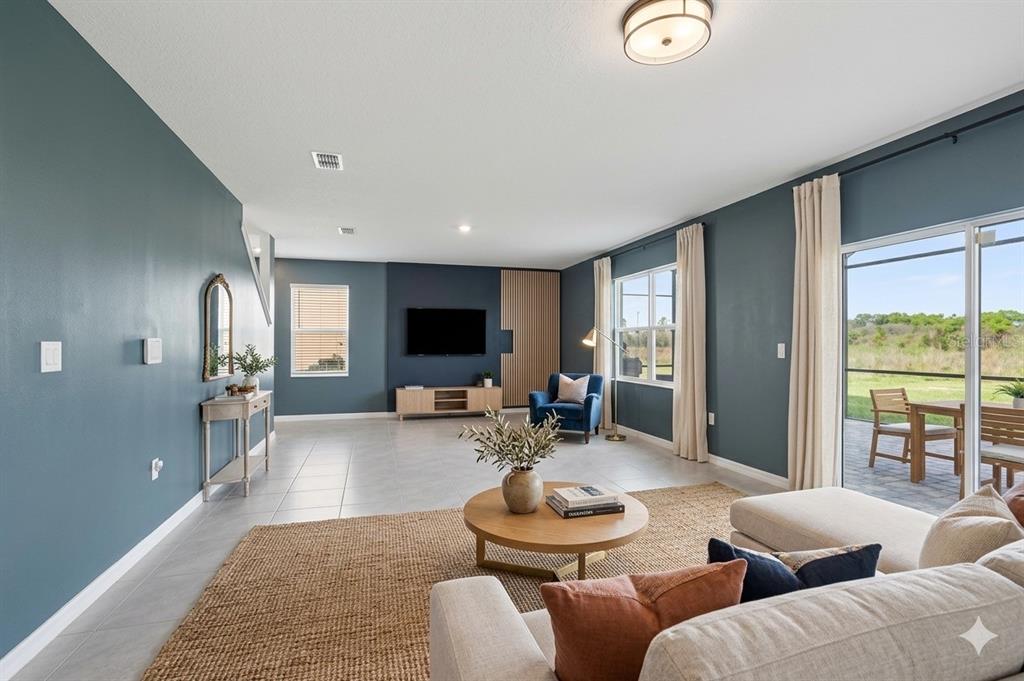 A living room features blue walls, a round coffee table, and a sliding glass door — 531 LAZIO CIRCLE, DEBARY, FL