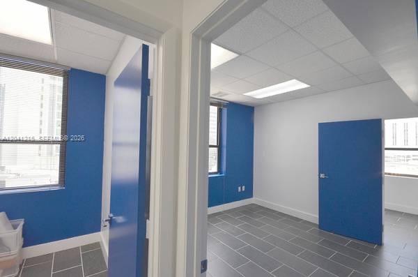 Two office rooms feature blue accent walls, gray tile flooring, and large windows — 168 SE 1st St # 501, Miami FL 33131, MIAMI, FL