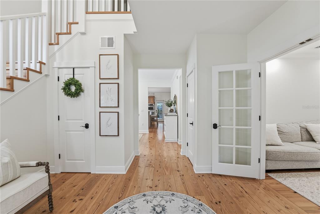 A bright foyer features hardwood floors, a staircase, and doorways leading to other rooms — 1190 SUGAR BELT DRIVE, ST CLOUD, FL