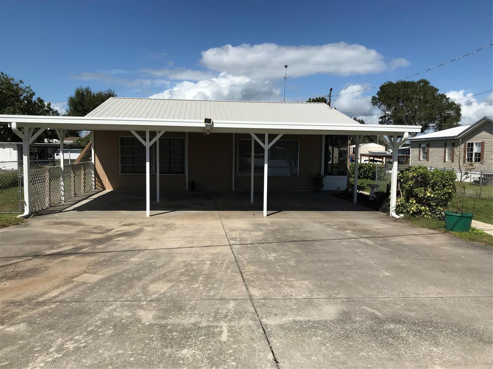 A single-story house with a large metal-roofed carport and a concrete driveway — 1112 21st Street, Okeechobee FL 34974, OKEECHOBEE, FL