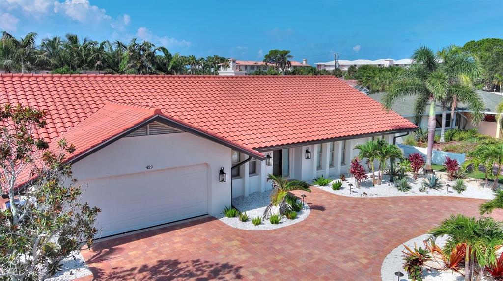 An exterior view of a single-story house with a red tile roof and paved driveway — 429 DARLING DRIVE, VENICE, FL