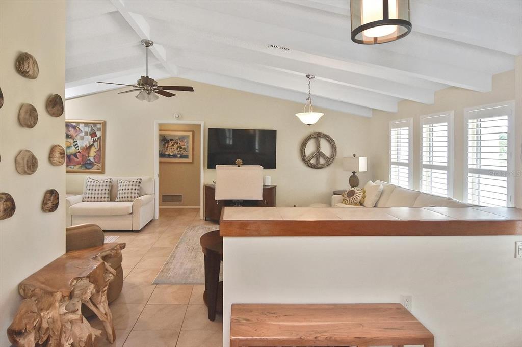 A living room features vaulted ceilings, tile flooring, a ceiling fan, and a wall-mounted television — 429 DARLING DRIVE, VENICE, FL