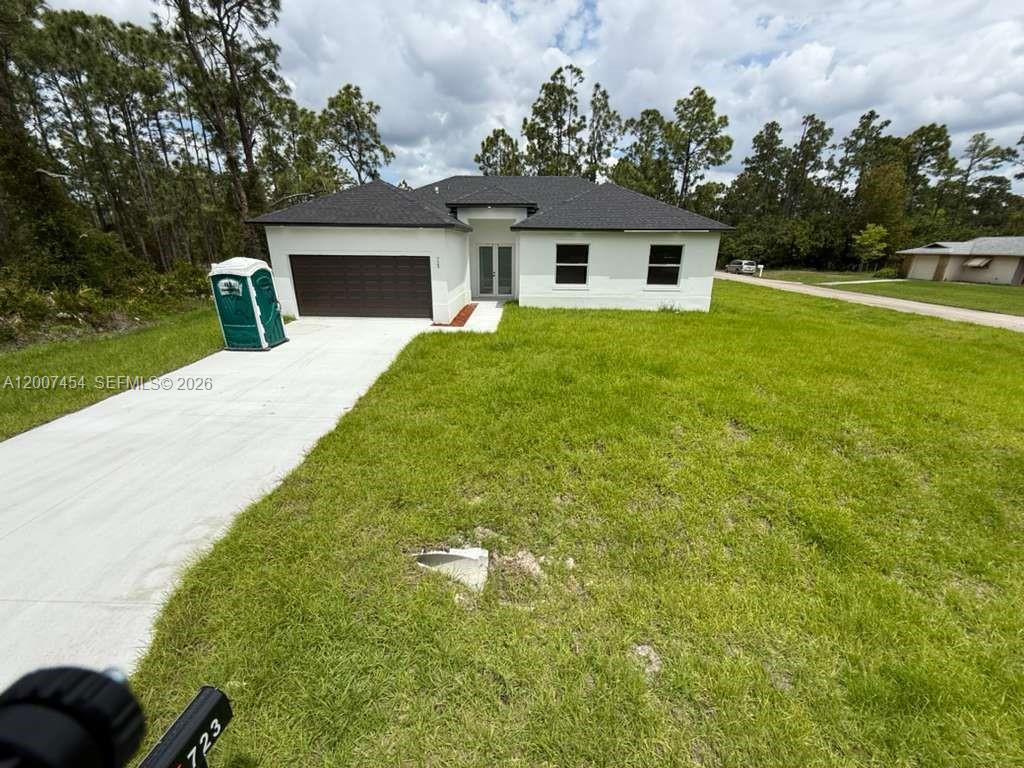 A newly constructed single-story house with a white exterior, dark roof, and attached garage — 723 EPPS BROWN ST E # 723, Lehigh Acres FL 33974, LEHIGH ACRES, FL
