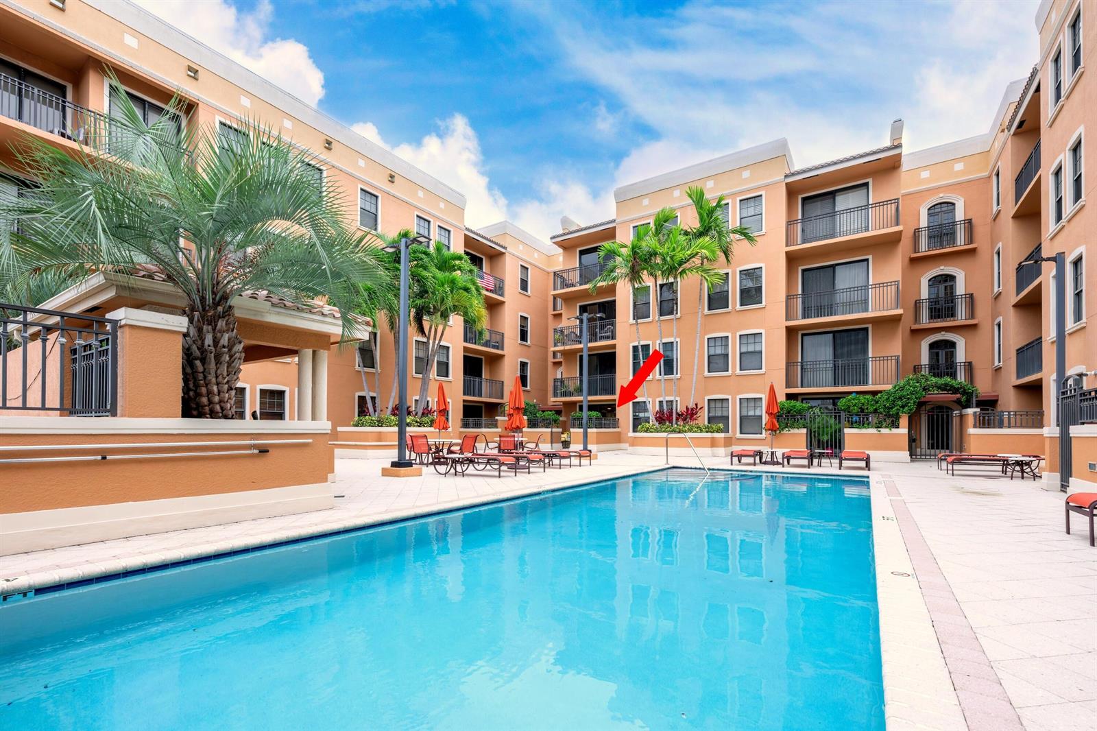 A swimming pool sits in the courtyard of a multi-story apartment complex with balconies — 511 Lucerne Avenue # 312, FL 33460, FL