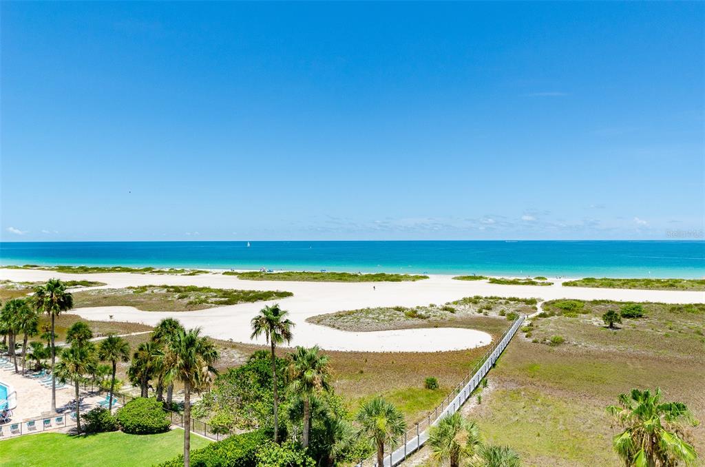 An elevated view of a sandy beach, dunes, and ocean under a clear blue sky — 1250 GULF BOULEVARD UNIT 703, CLEARWATER BEACH, FL
