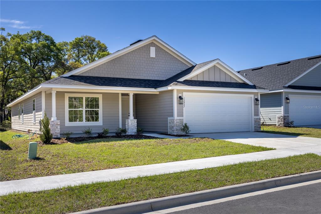A single-story suburban house with gray siding, a two-car garage, and a covered porch — 17766 NW 168TH ROAD, ALACHUA, FL