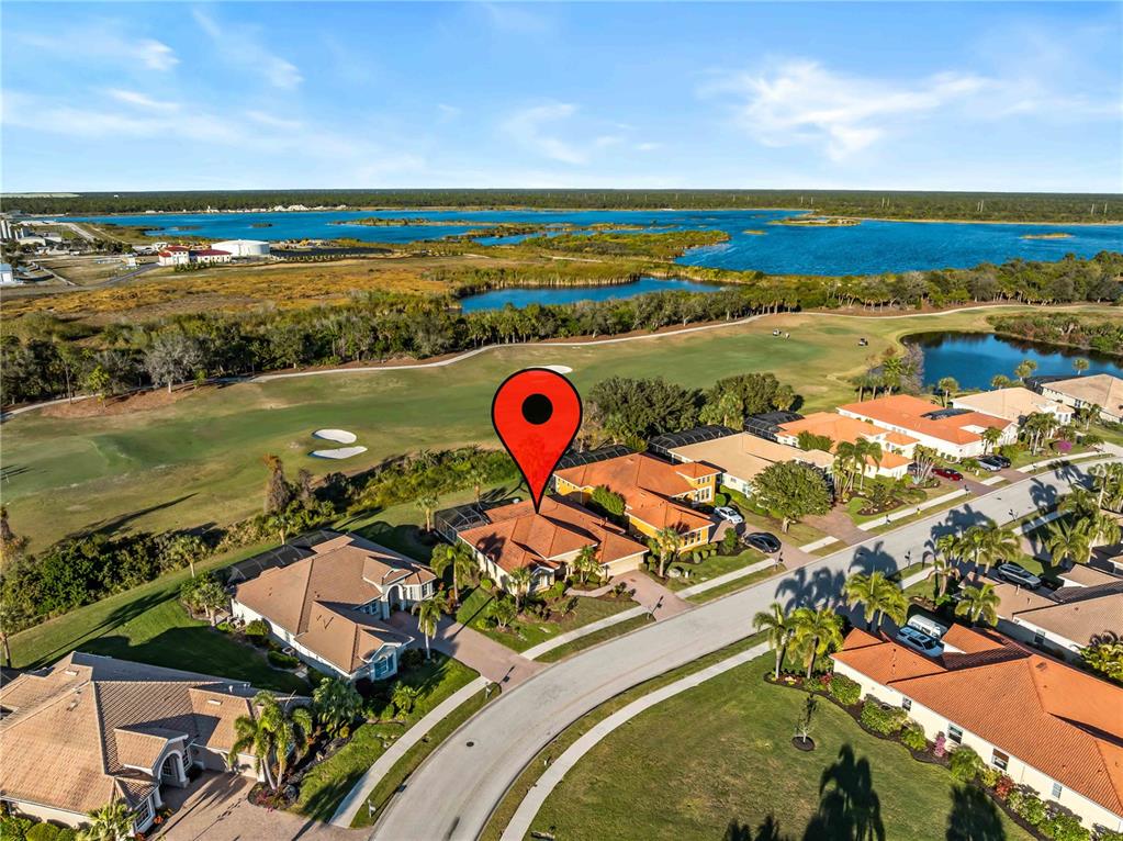 An aerial view shows a residential house with a red pin on a golf course — 274 MONTELLUNA DRIVE, NORTH VENICE, FL