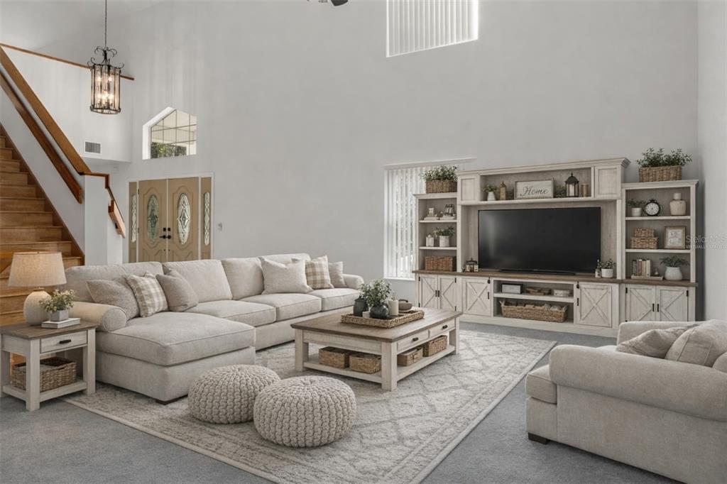 A living room with a sectional sofa, coffee table, entertainment center, and stairs — 5248 NEFF LAKE ROAD, BROOKSVILLE, FL
