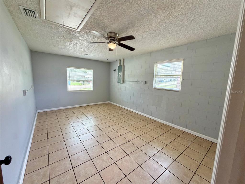 An interior room features tile flooring, a ceiling fan, and a painted cinder block wall — 8 N HENDRY AVENUE, FORT MEADE, FL