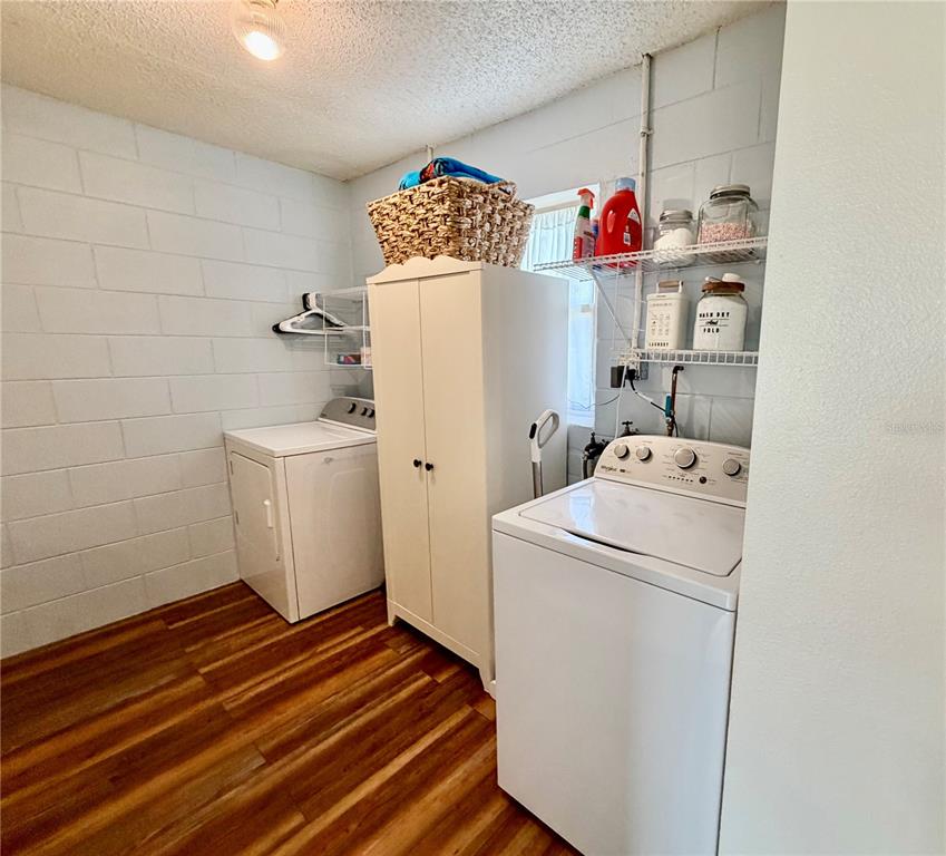 A laundry room features white appliances, a storage cabinet, and wire shelving against block walls — 8 N HENDRY AVENUE, FORT MEADE, FL