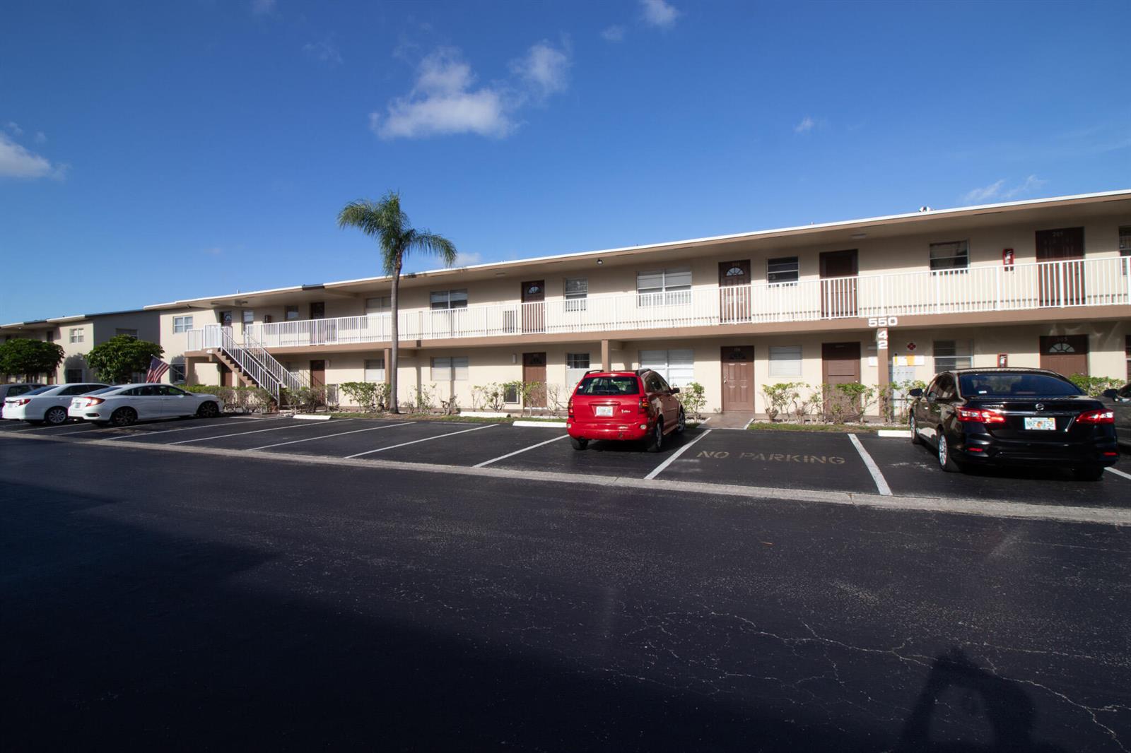 A two-story apartment building with a parking lot in the foreground under a blue sky — 550 NW 77th Avenue # 204, Margate FL 33063, MARGATE, FL