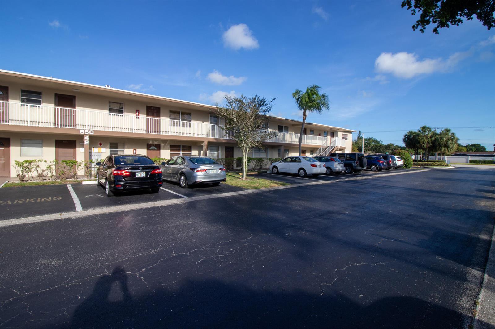 A two-story apartment building with a parking lot in the foreground under a blue sky — 550 NW 77th Avenue # 204, Margate FL 33063, MARGATE, FL