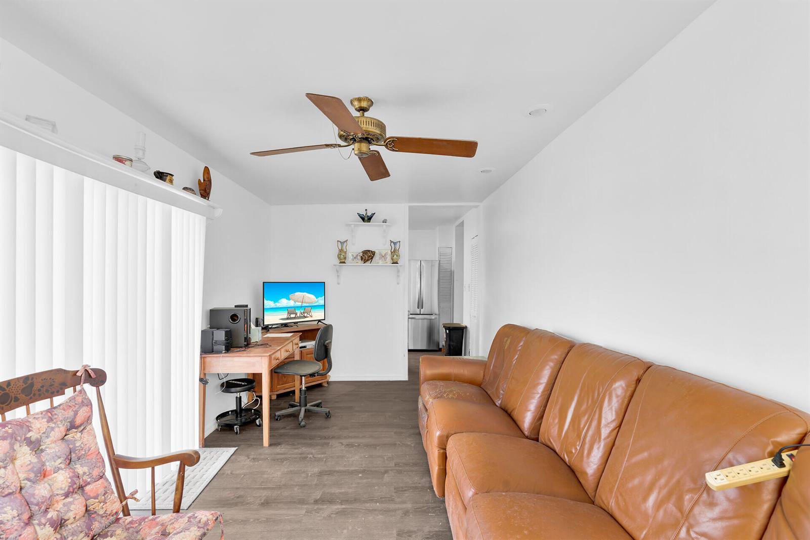 A living room features a brown leather sofa, a wooden desk, and a ceiling fan — 4 Shore Drive, Key West FL 33040, KEY WEST, FL