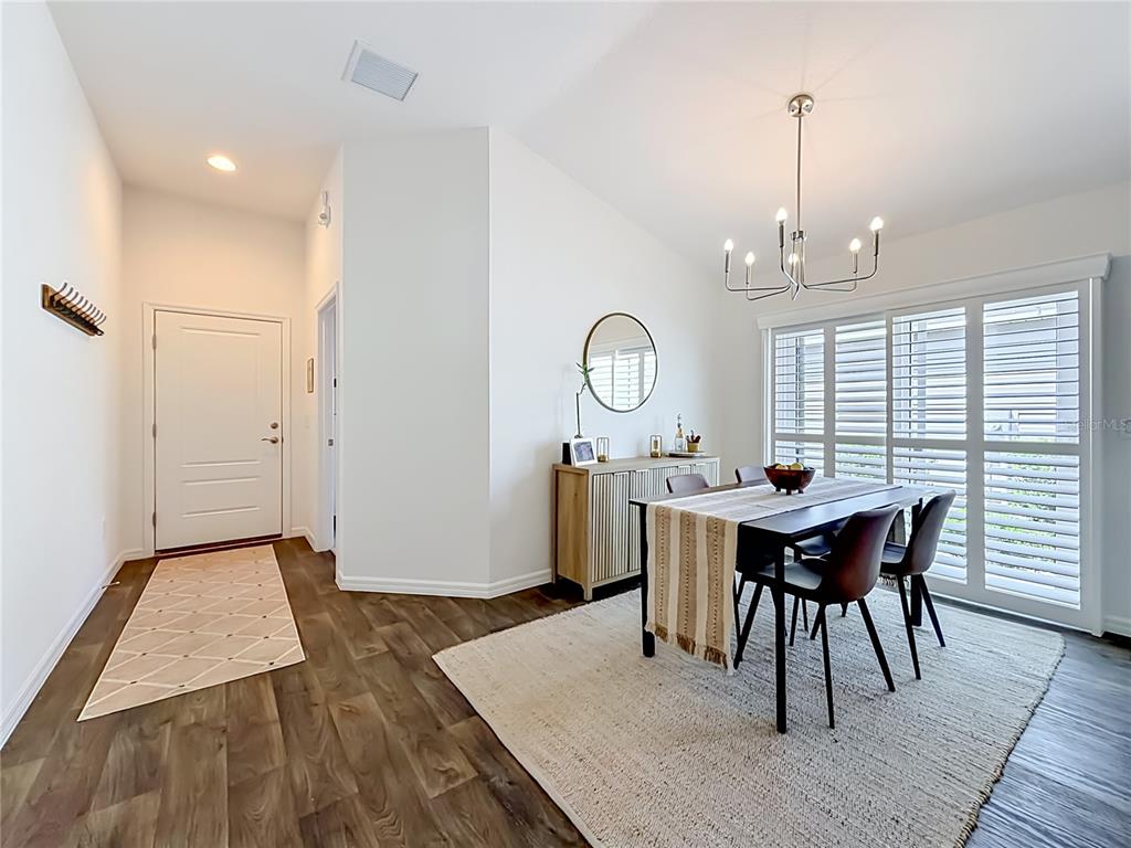 A dining room with a table, chairs, sideboard, and plantation shutters on the windows — 6231 ATKINSON LANE, THE VILLAGES, FL